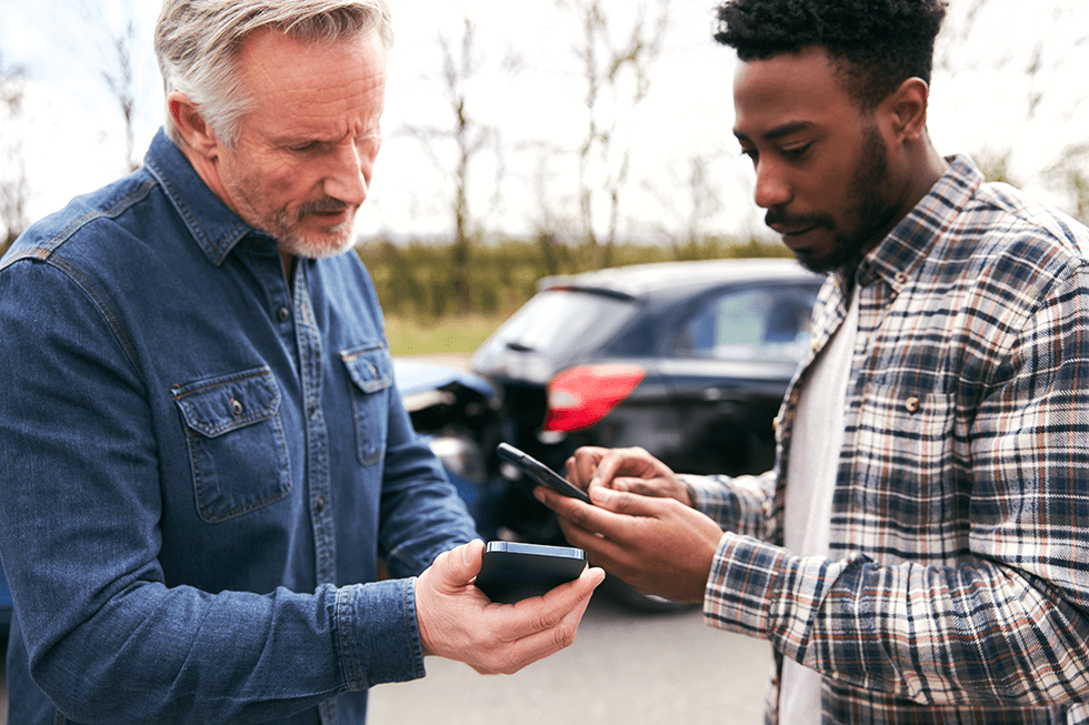 Two men exchanging information after a rideshare accident