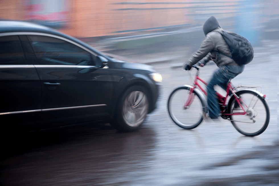 A black car moments before hitting a bicyclist riding in the rain at a Delray Beach intersection
